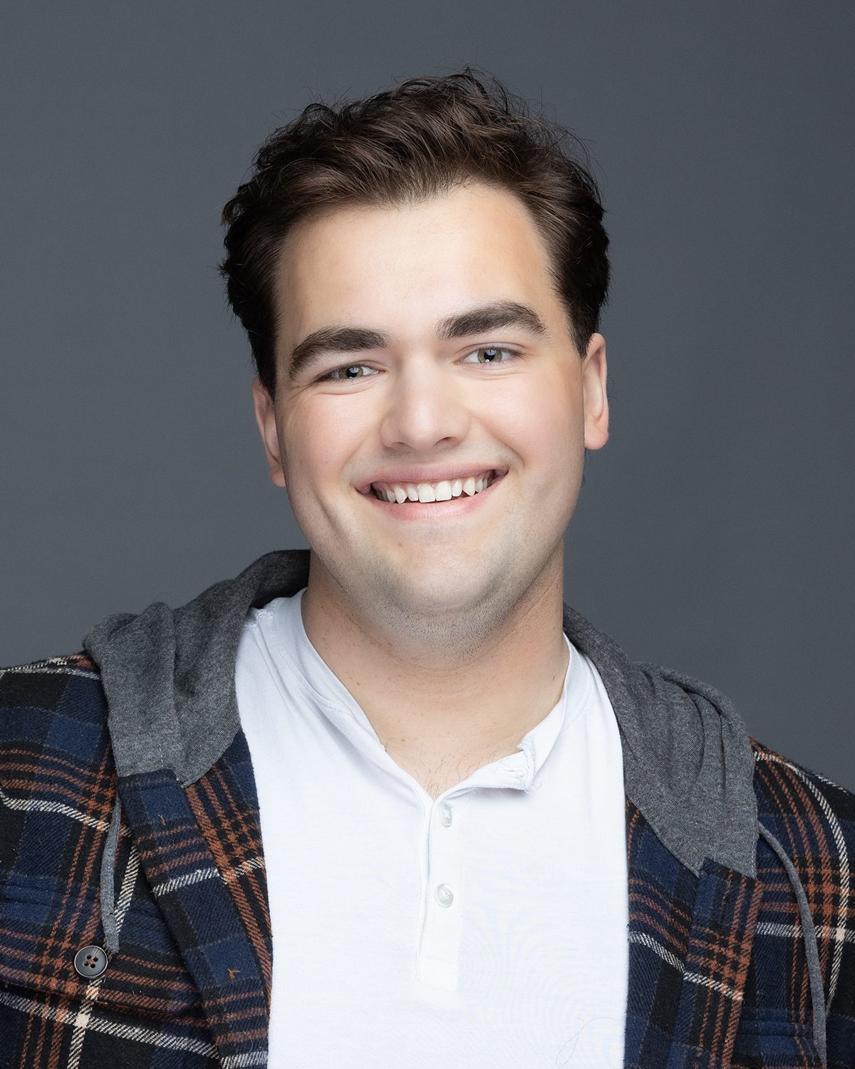 Lifestyle actor headshot of Benjamin Blount in a plaid and hoodie layered look, Ashland Oregon