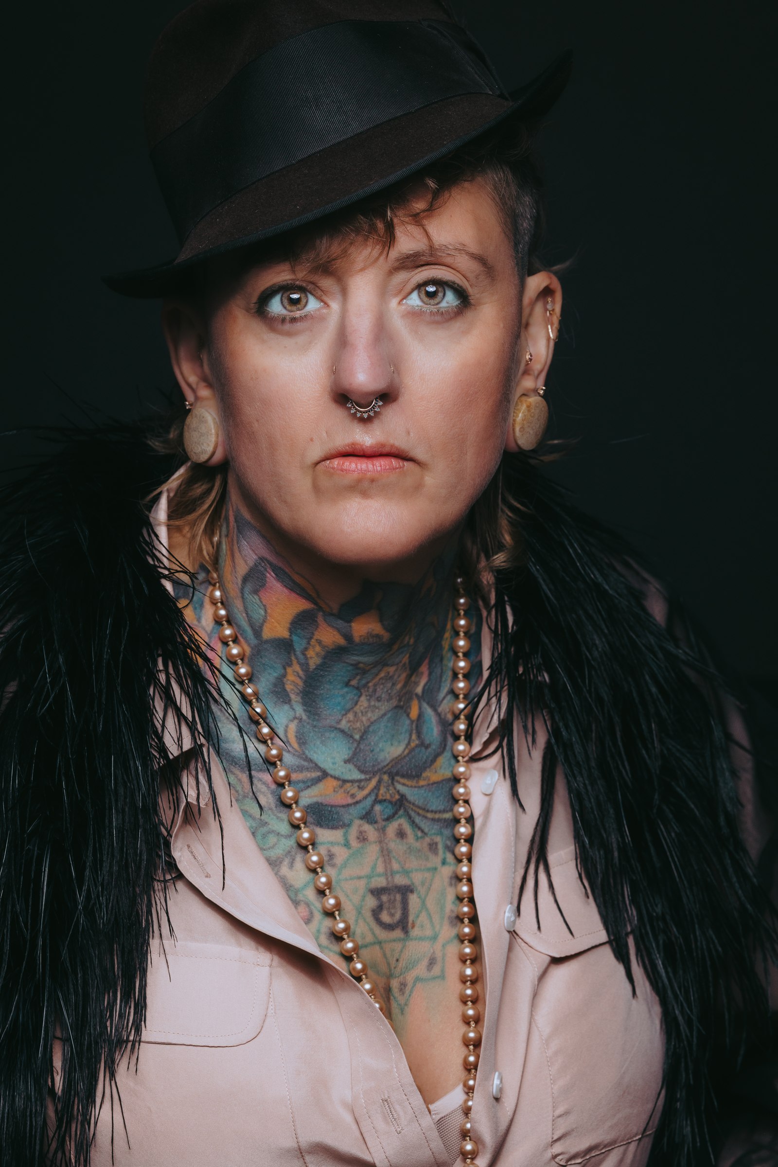 Portrait of Chari in a feathered collar and pearl necklace