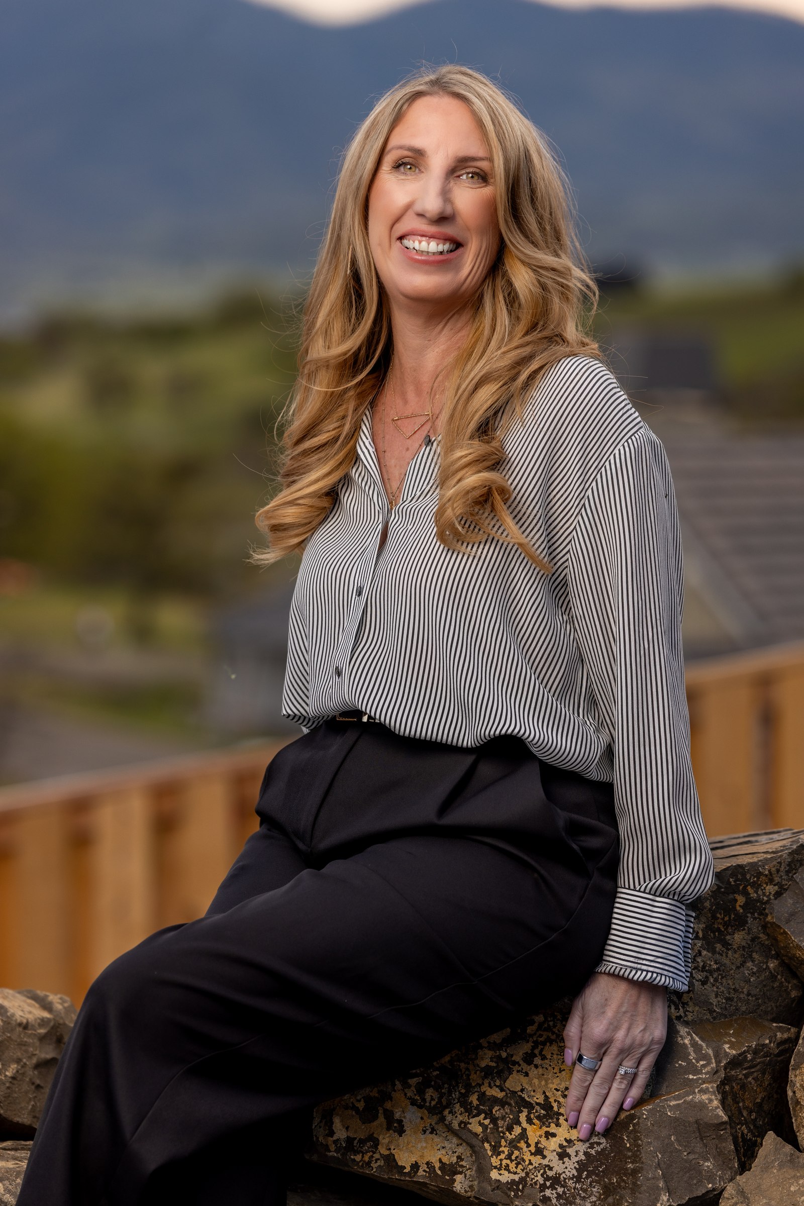 Female team member, outdoor environmental portrait with mountain backdrop