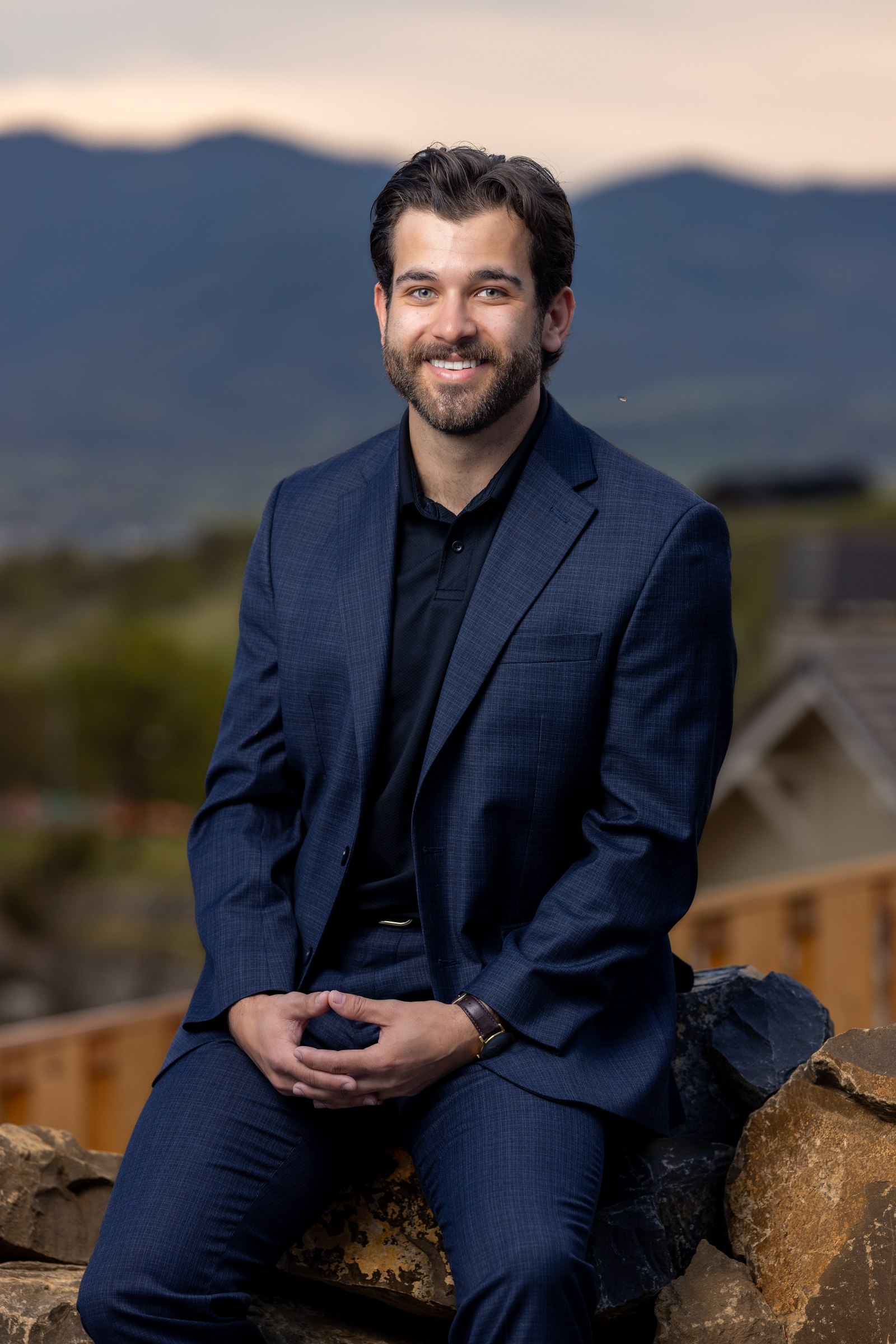 Male team member, outdoor environmental portrait with mountain backdrop