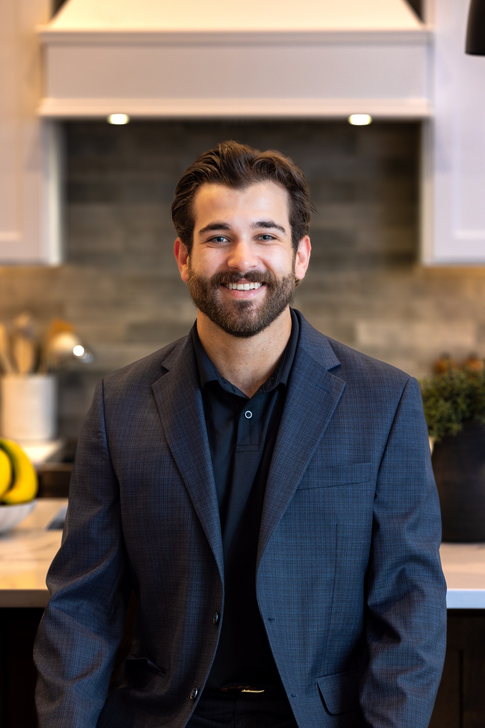 Male team member, professional indoor headshot in a tailored blazer
